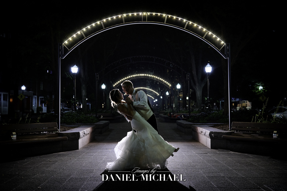 Couple on sidewalk with arch lights